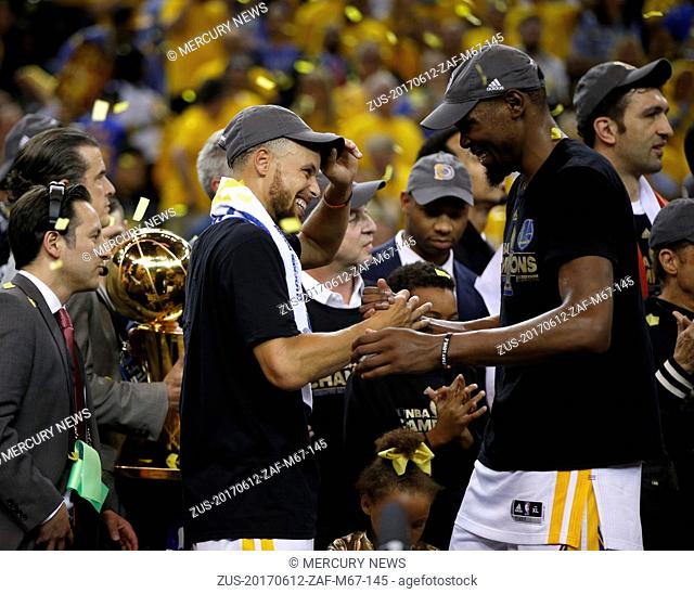 June 12, 2017 - Oakland, CA, USA - The Golden State Warriors' Stephen Curry and Kevin Durant, right, celebrate after defeating the Cleveland Cavaliers, 129-120