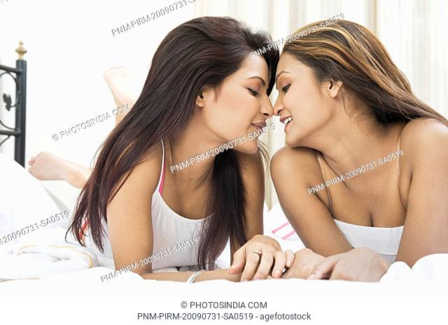 Lesbian couple romancing on the bed