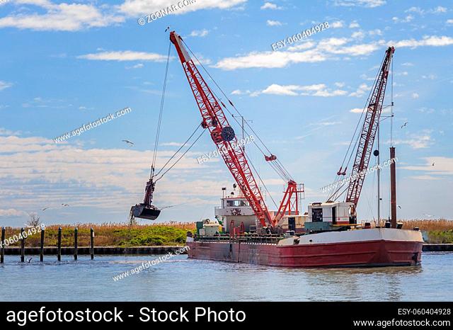 Marano, Italy -02 April 2015 : Dredger ship navy working to clean a navigation channel