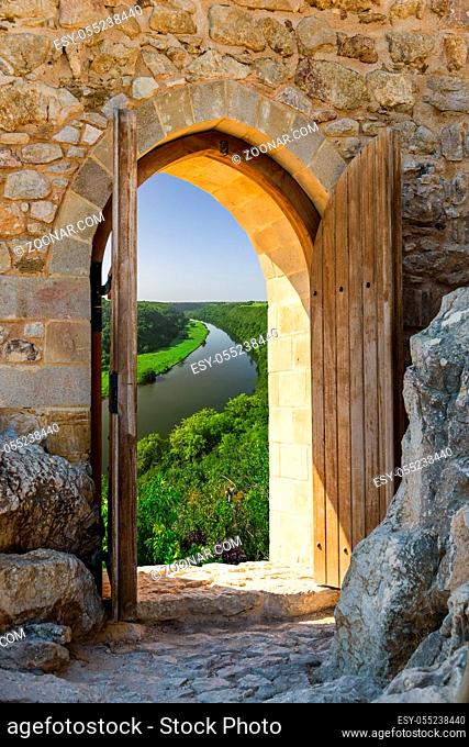 old wooden arch in the fortress with open doors overlooking the natural landscape