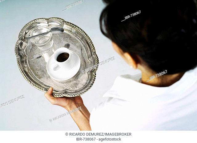 Waitress delivering coffee on silver tray