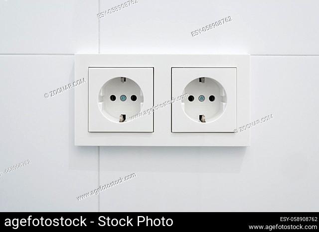 double socket, new electric plug on white tiles -