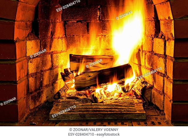 burning firewood in brick fireplace