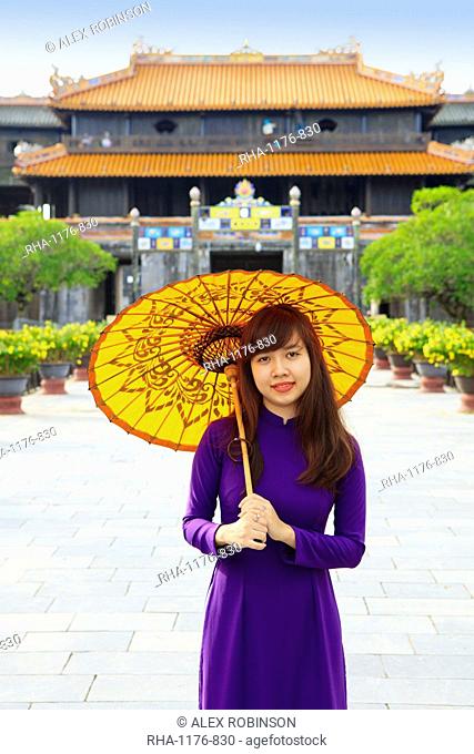 Woman in a traditional Ao Dai dress with a paper parasol in the Forbidden Purple City of Hue, UNESCO World Heritage Site, Thua Thien Hue, Vietnam, Indochina