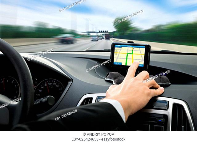 Close-up Of A Person's Hand Using Gps Navigation System In Car