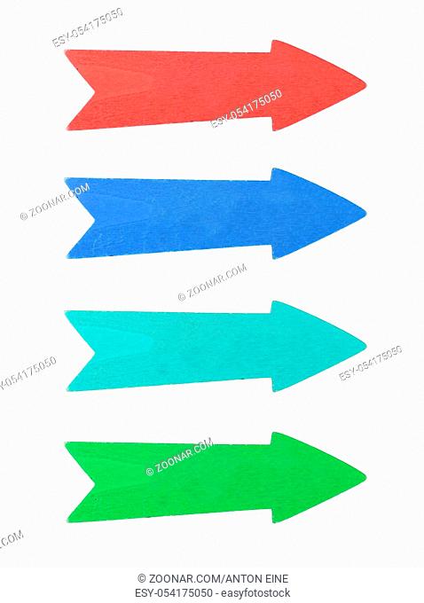 Four multicolor painted wooden direction arrows, red, blue, teal and green, isolated on white background, close up