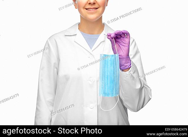 smiling female doctor holding medical mask