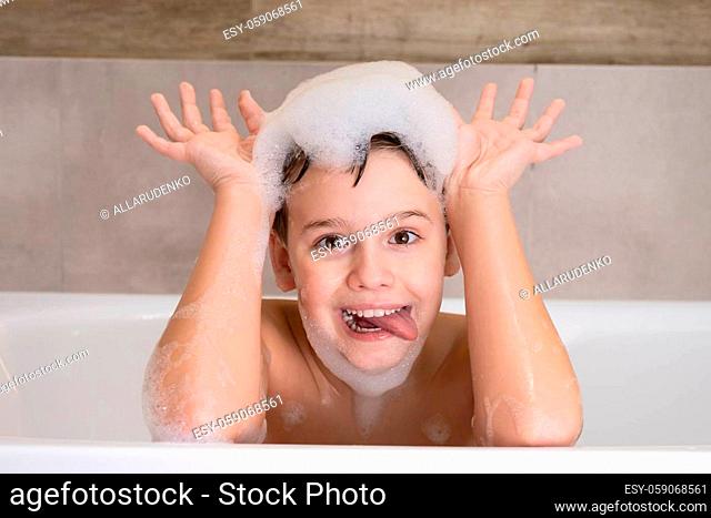 Closeup portrait of funny boy playing with water and foam in bathroom Cute happy child bathe and makes funny faces healthy childhood