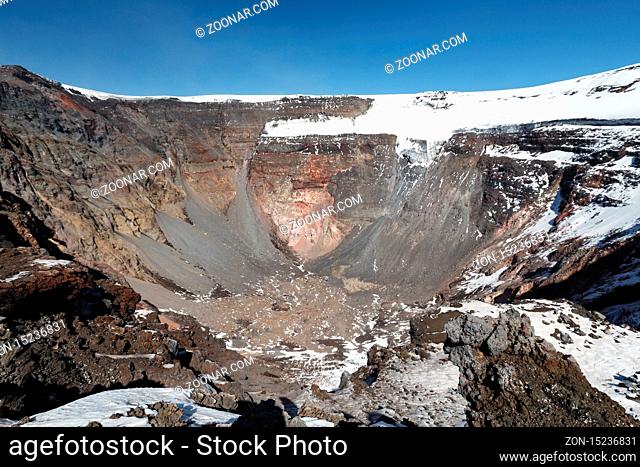 Volcanic landscape of Kamchatka Peninsula: view of large summit crater of active Tolbachik Volcano with steep sides and glaciers
