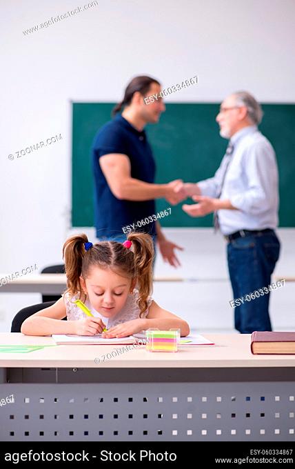 Young parent, old teacher and little girl in the classroom
