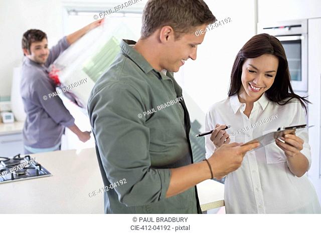 Woman signing for delivery in kitchen