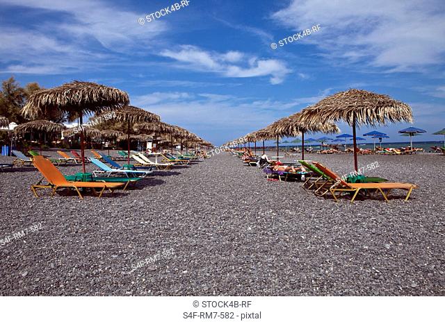 Sun loungers and sunshades on the beach, Santorini, Greece
