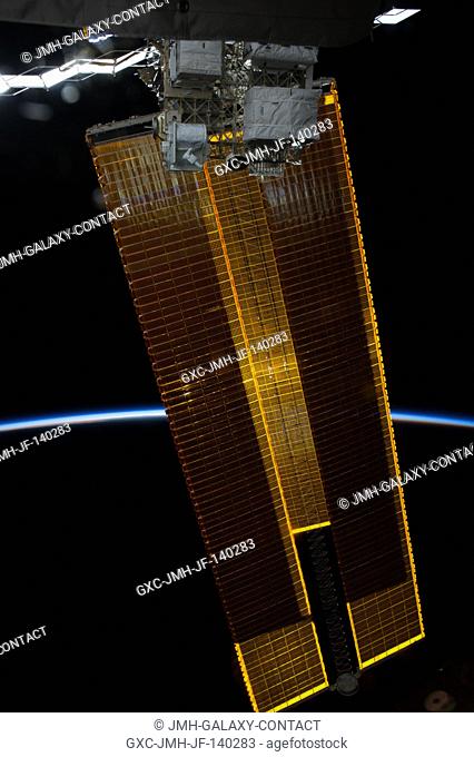 Intersecting the thin line of Earth's atmosphere, International Space Station solar array wings are featured in this image photographed by an Expedition 40 crew...
