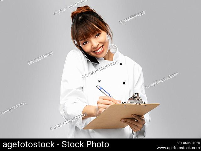 happy female chef with clipboard calling on phone