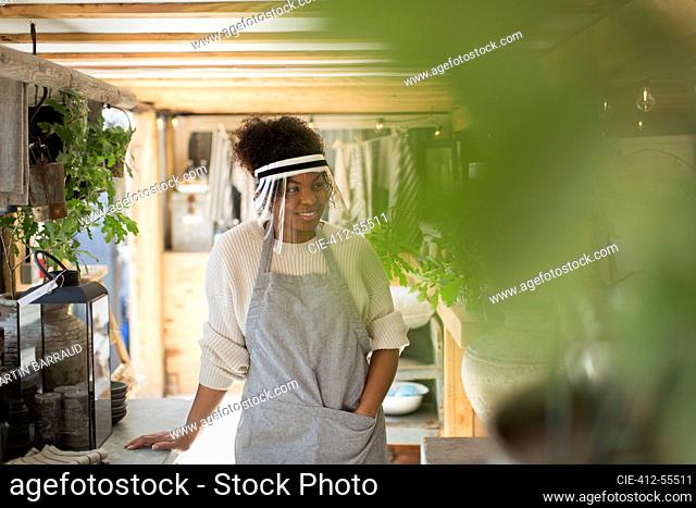 Woman in protective face shield working in plant nursery