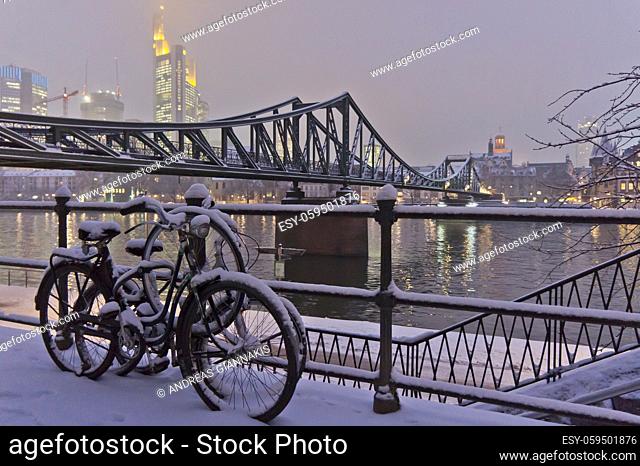 Frankfurt, Snowy night city view by the river Rhein, Snowy Bicycles, Germany, Europe