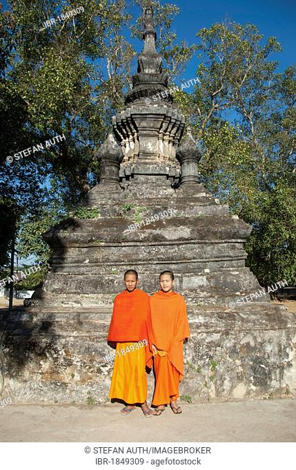 Two monks in orange robes in front of a stupa, novices, Vat Aham, Wat, Luang Prabang province, Laos, Southeast Asia, Asia