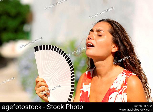 Woman suffering heat stroke in a town street on summer