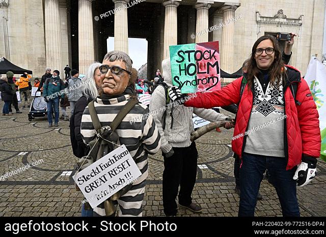 02 April 2022, Bavaria, Munich: Demonstrators stand under the motto ""We run for self-determination in vaccination"" on the Königsplatz with posters with the...