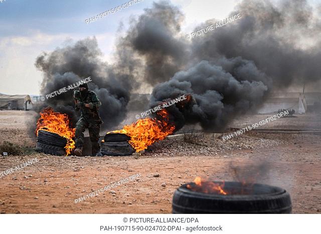 15 July 2019, Syria, Idlib: Fighters of Jaysh al-Izza formation of the Syrian armed opposition, take part in a military show during their graduation from a...