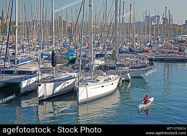 Yachts in the harbor, sunny day in harbor, man on a canoe