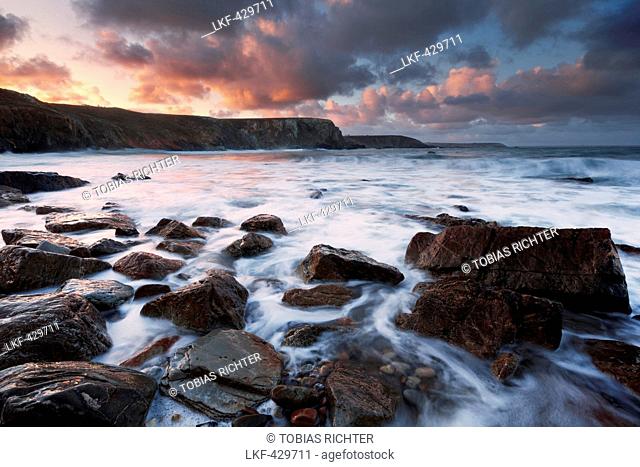 Sunrise above the rocky coast of the Crozon peninsula in north-west France with breakers in the foreground, Brittany, France