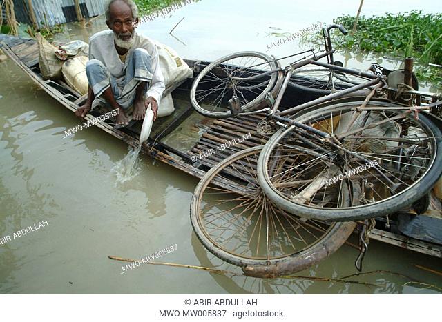 An old man bailing water from a boat in the flood affected area Gaibandha, Bangladesh July 21, 2004