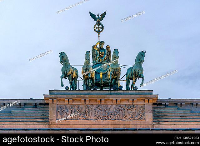 December 28, 2020, Berlin, Detail of the Brandenburg goal on a winter afternoon. The lighting of the Brandenburg goal shines on the quadriga and creates a...