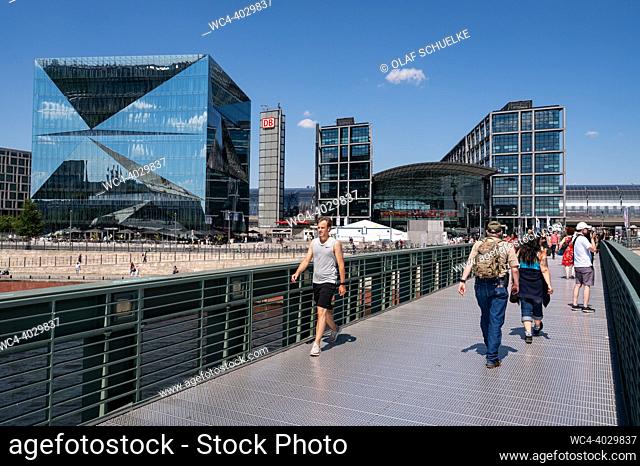 Berlin, Germany, Europe - People, including many visitors and tourists, cross the Gustav Heinemann Bridge with Berlin Central Station and the futuristic 3XN...