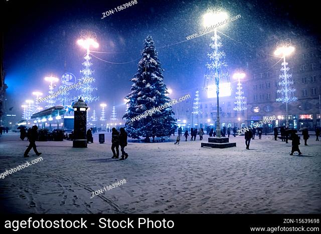Zagreb, Croatia: January 6 2016: Zagreb main square at night with blue lightened christmas trees during snow storm, Croatia