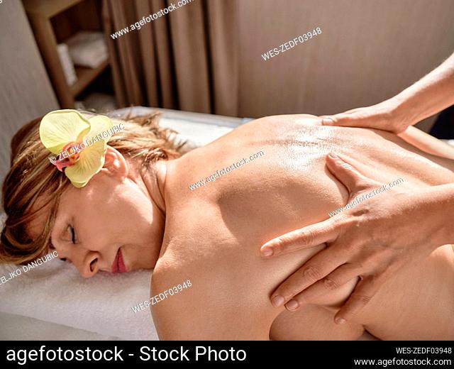 Hand of mature woman giving back massage to senior woman