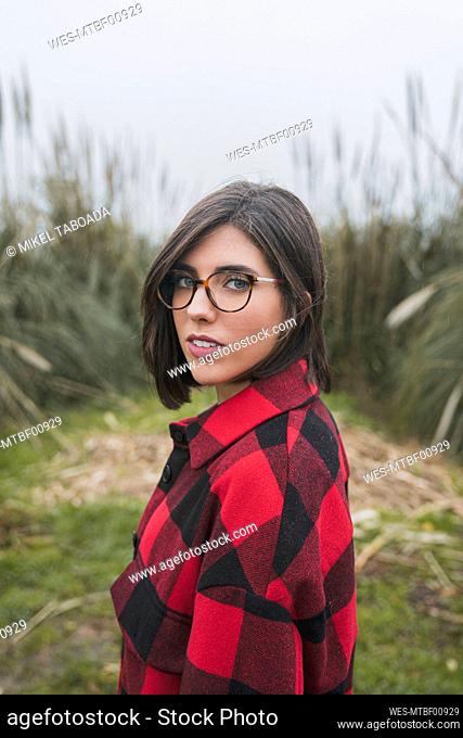 Young woman with eyeglasses standing at agricultural field
