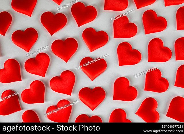 Valentine's day many red silk hearts on white background, love concept