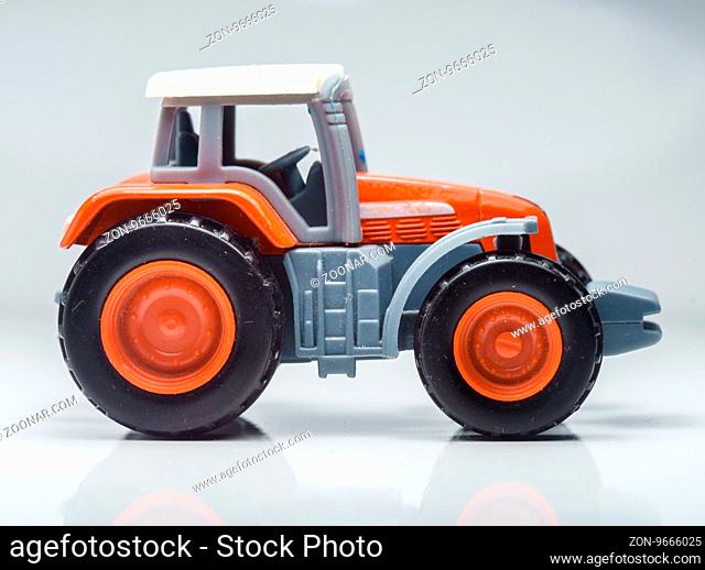 Closeup Of Small Red Agricultural Toy Tractor, Icon Farmer Machinery, Agriculture Business Concept