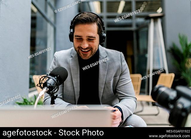 Businessman talking on microphone while sitting at cafe