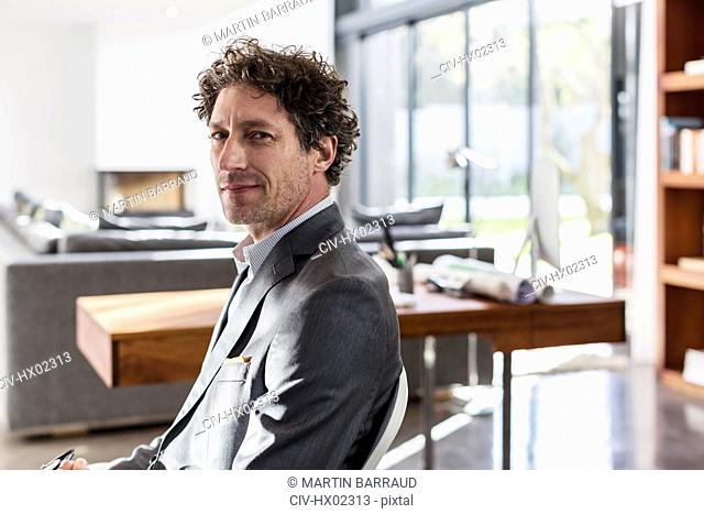 Portrait confident male architect in home office