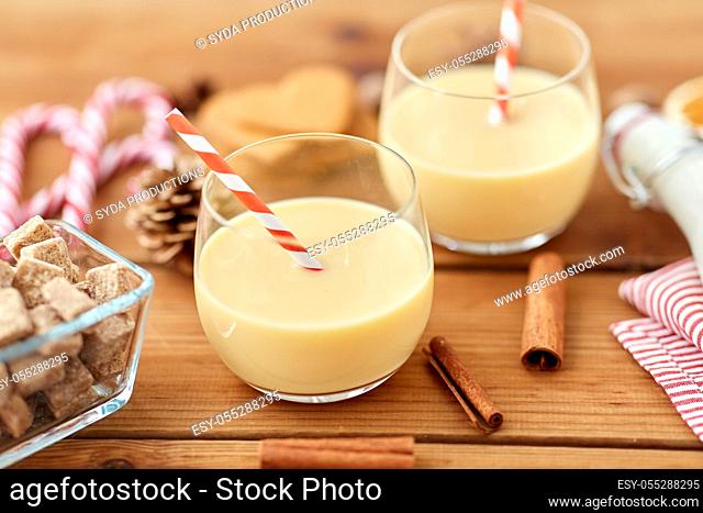 glasses of eggnog, ingredients and spices on wood