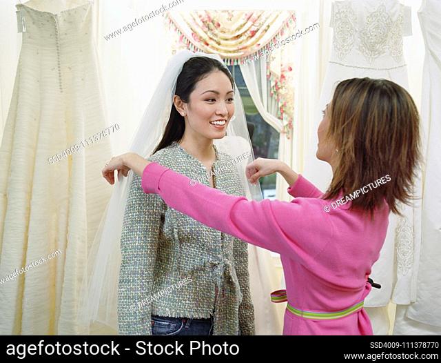 Young woman wearing a veil in a bridal boutique