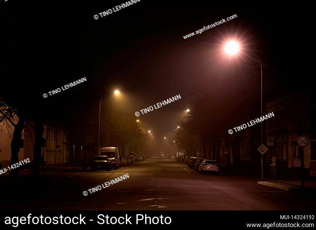 Germany, Luckenwalde, February 28, 2022, subtle fog at night in the streets of the small town of Luckenwalde