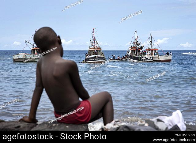 boy watching boats at the fishermen's party in Cidade Velha, Cape Verde