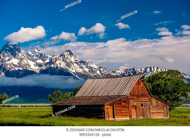 Old mormon barn in Grand Teton Mountains with low clouds. Grand Teton National Park, Wyoming, USA