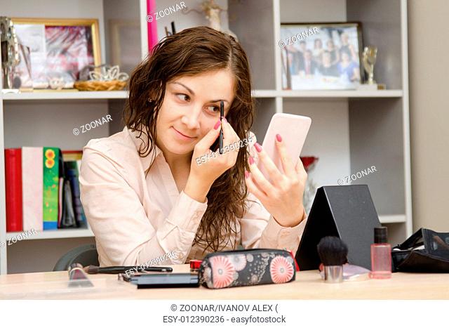 girl at work paints eyebrow mascara