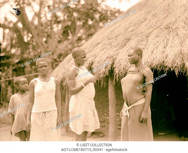 Uganda. From Hoima to Fort Portal. Hut with native young women and children. Close up. 1936, Uganda