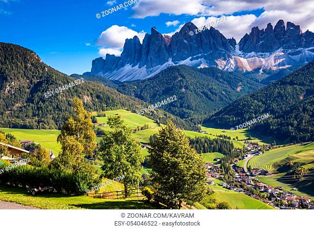 Dolomites, Val de Funes valley. Lovely autumn day. Picturesque mountains surround the green alpine meadows of the valley