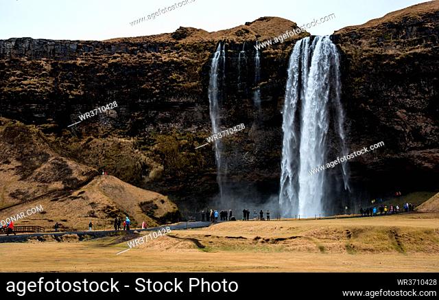Skogafoss, Iceland, March 3 2016: Tourists enjoying the Skogafoss waterfall and skoga river, river in south Iceland