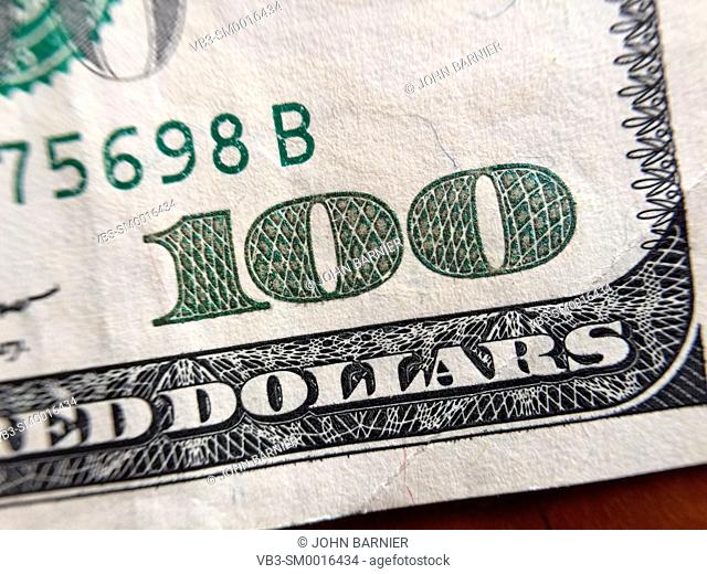 Closeup of the number 100 in the corner of a $100 bill