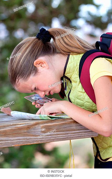 Girl peering at map with magnifier, Sedona, Arizona, USA