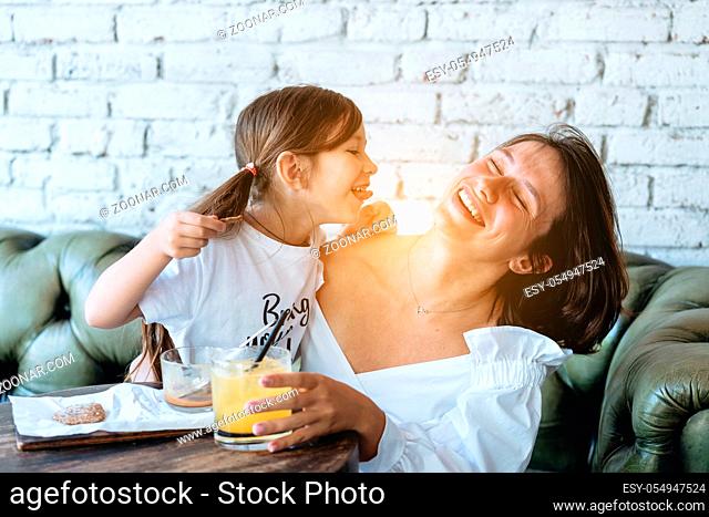 Mom and her little girl have fun in the room on the couch