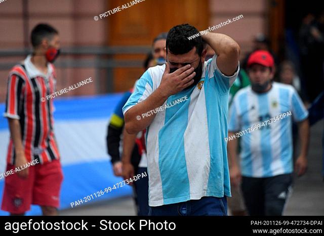 26 November 2020, Argentina, Buenos Aires: A fan wipes away his tears after paying his last respects to Diego Maradona in the Casa Rosada