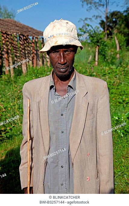 portrait of an elderly Tutsi man with jacket, hat and walking stick, Burundi, Cankuzo, Near National Parc de la Ruvubu, Cankuzo
